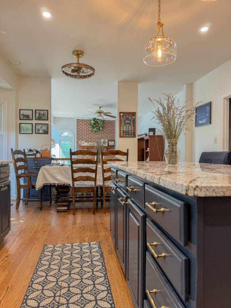 a kitchen with oak flooring, blue cabinets, and a marbled countertop